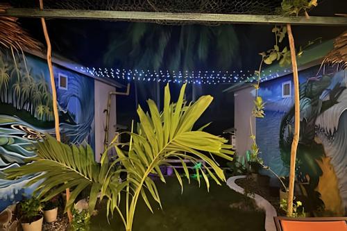 a mural of a house with plants and lights at Casa Las Palmas Playa La Saladita in Zihuatanejo