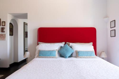 a bedroom with a large white bed with a red headboard at Capo Santa Fortunata in Sorrento