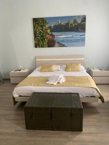 a bedroom with a large bed with a painting on the wall at Ca' Garibaldi Rooms in Bassano del Grappa