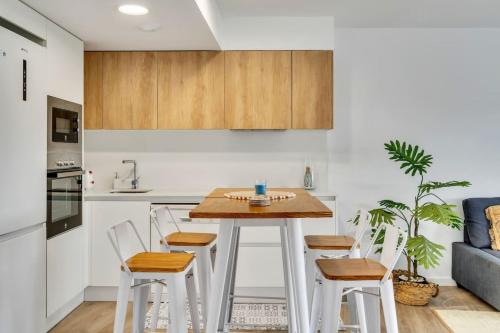 a kitchen with a wooden table and chairs at Retiro Glamuroso,Piscina,Terraza,10min dist playa in Jávea