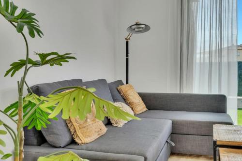 a living room with a gray couch and a plant at Retiro Glamuroso,Piscina,Terraza,10min dist playa in Jávea