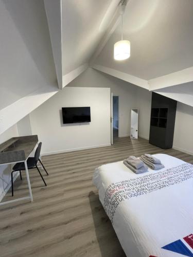 Un dormitorio con una cama, un escritorio y un televisor. en Maison 100m2 uniquement famille, couple & professionnel, en Villeparisis