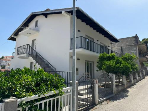 a white house with a fence and trees at FRANE-APART - Čiovo in Trogir