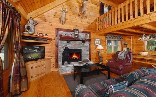 a living room with a fireplace in a log cabin at Holden On in Pigeon Forge