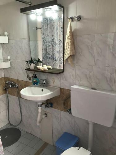 a bathroom with a sink and a toilet and a mirror at Koralia Summer House in Lióta