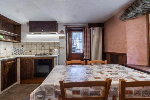 a kitchen with a table and chairs in a kitchen at Seconda stella a destra in Valgrisenche
