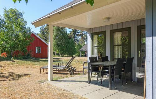 a patio with a table and chairs and a barn at Awesome Home In Aakirkeby With Wifi in Vester Sømarken