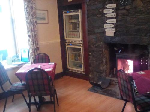 a dining room with a fireplace and a table and chairs at The Merchants House in Cairnryan