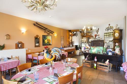 a restaurant with tables and chairs and a clock at Hôtel de la Poste in Malbuisson