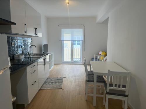 a kitchen with a table and a dining room at Cardigos Village Apartments in Mação