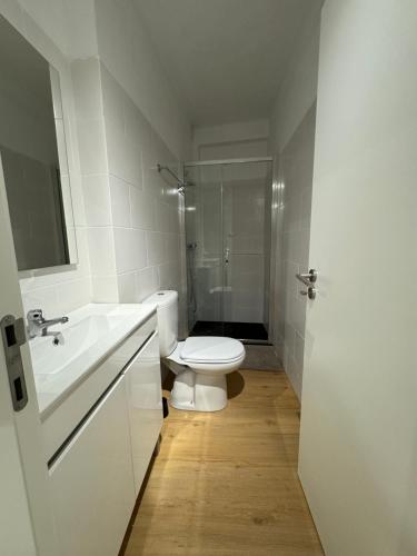 a white bathroom with a toilet and a shower at Cardigos Village Apartments in Mação