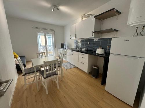 a kitchen with a table and a white refrigerator at Cardigos Village Apartments in Mação
