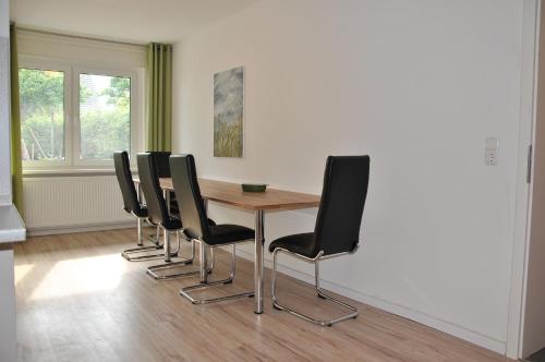 a conference room with a wooden table and black chairs at Ferienwohnung direkt in Sassnitz in Sassnitz