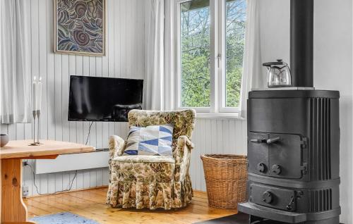 a living room with a chair and a stove at Holiday Home Nordvangsvej With Fireplace And Shower in Allingåbro