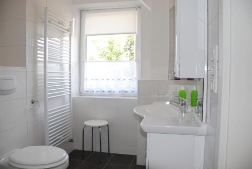a white bathroom with a sink and a toilet at Ferienwohnung direkt in Sassnitz in Sassnitz