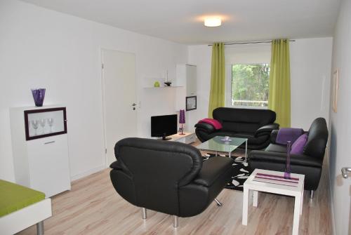 a living room with two black chairs and a table at Ferienwohnung direkt in Sassnitz in Sassnitz