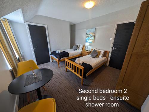 a small hotel room with two beds and a table at Coasters Holiday Apartments in Skegness