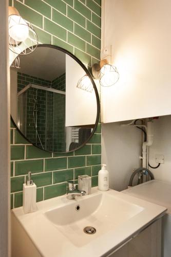 une salle de bain avec un lavabo et un miroir dans l'établissement L'escapade studio en Hypercentre Cathédrale, à Amiens
