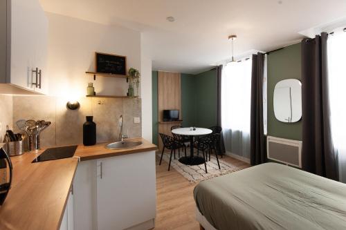 Cette chambre comprend une cuisine avec un lit et une table. dans l'établissement L'escapade studio en Hypercentre Cathédrale, à Amiens