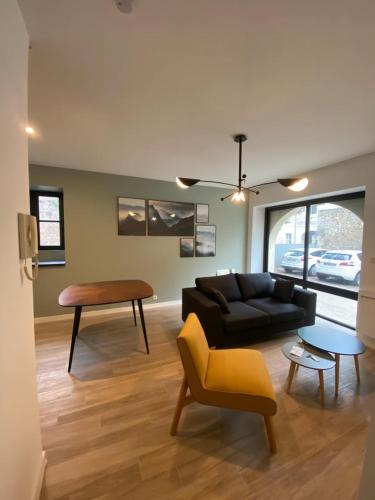 un salon avec un canapé noir et une table dans l'établissement Le Céleste: Hypercentre, quiet and parking, à Poitiers