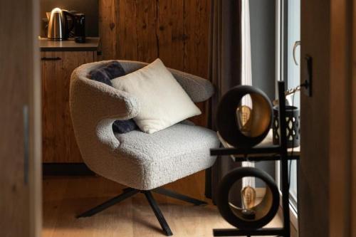 a chair with a pillow sitting next to a window at Schöneben Appartementen Top 3 in Wald im Pinzgau