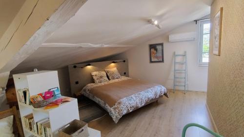 a bedroom with a bed in a attic at 16 Bis-Gîte-Hôtel-Appartement in Marssac-sur-Tarn