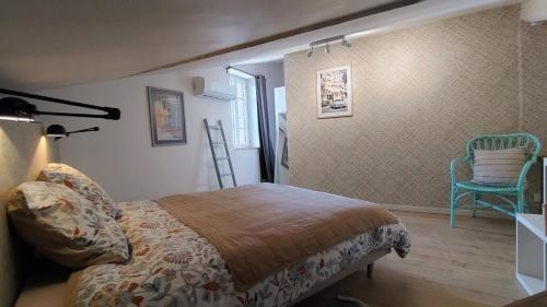 a bedroom with a bed and a blue chair at 16 Bis-Gîte-Hôtel-Appartement in Marssac-sur-Tarn