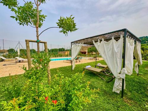 a garden with a swing and a pool at Giotto Country House & Spa in Assisi