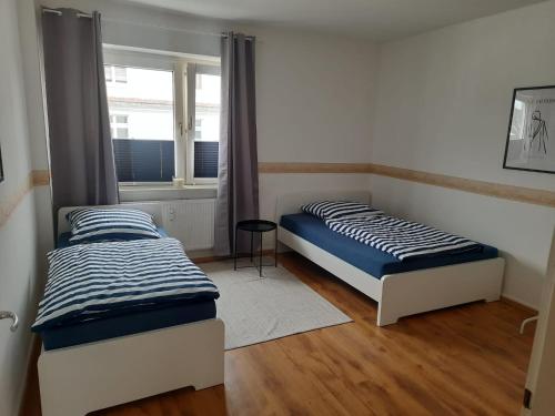 two beds in a room with a window at Fußball-Kultur Appartement Gelsenkirchen Schalke in Gelsenkirchen
