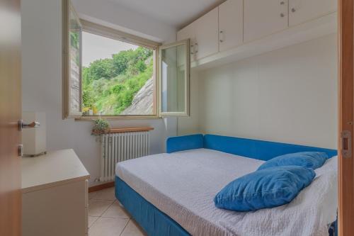 una camera da letto con un letto con cuscini blu di Casa Andrea Varenna a Perledo