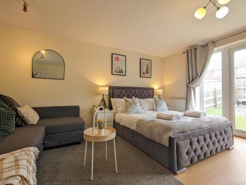 a bedroom with a bed and a couch at Large 4-Bedrooms House Near Centre Free Parking in Liverpool