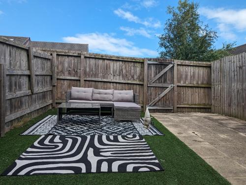 a patio with a couch and a fence at Large 4-Bedrooms House Near Centre Free Parking in Liverpool