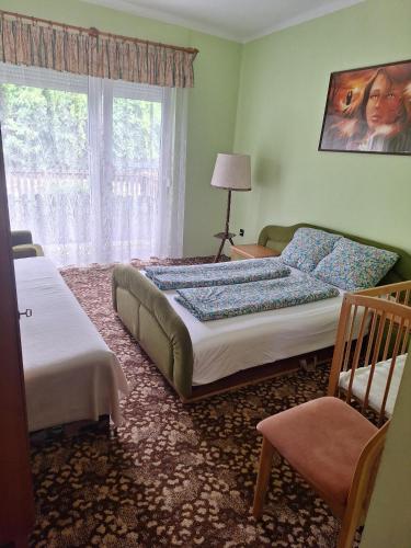 a bedroom with two beds and a window at Etus Vendéghaz 2 in Balatonfenyves