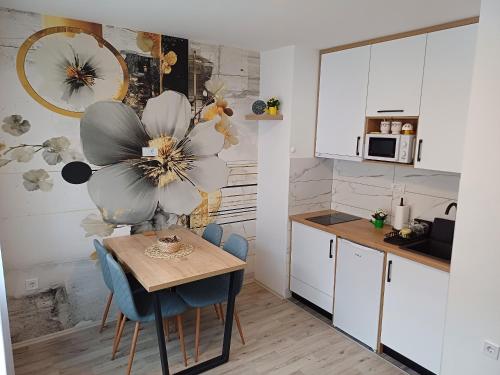 a kitchen with a table and blue chairs in a kitchen at Eva apartman in Gornji Milanovac