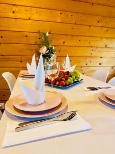 a table with a plate of food and wine glasses at Biale Domki Paula Rewal - Domki z klimatyzacja, w obiekcie Jacuzzi i darmowe Wifi! in Rewal