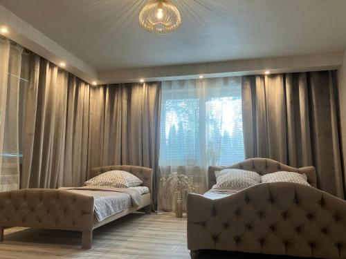 a bedroom with two beds and a window at Apartamenty Arkadia przy Amfiteatrze in Mrągowo