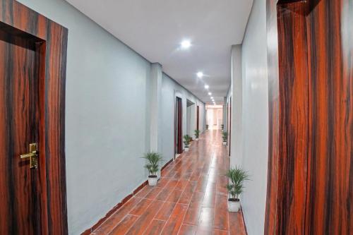 a hallway with potted plants on a wooden floor at Palette - The Mark Club & Resorts in Durg