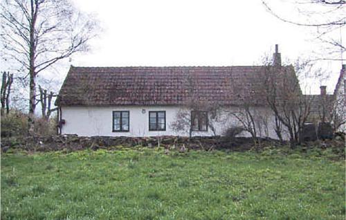 a white house with a red roof in a field at Holiday Home Komstad Stengravar Gärsnäs in Smedstorp
