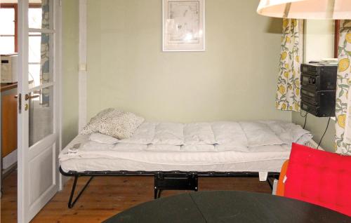 a bed sitting in a room next to a table at Holiday Home Komstad Stengravar Gärsnäs in Smedstorp