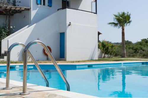 a swimming pool in front of a house at Marianthi Apts Anissaras in Hersonissos