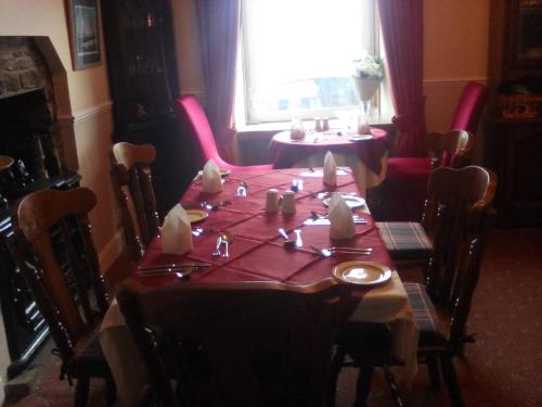 a dining room table with a red table cloth at The Merchants House in Cairnryan