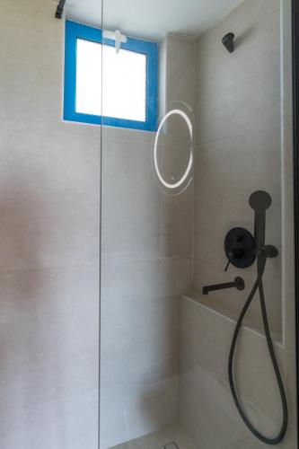a shower with a mirror and a window in a bathroom at Marianthi Apts Anissaras in Hersonissos