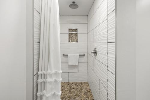 a bathroom with a shower with a white shower curtain at Willow - 99 Ridge Lane in Branson