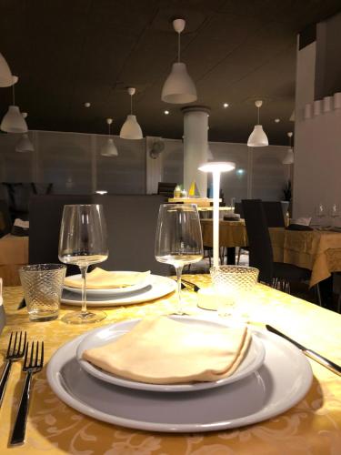 a table with two plates and wine glasses on it at Hotel La Parigina in Lignano Sabbiadoro