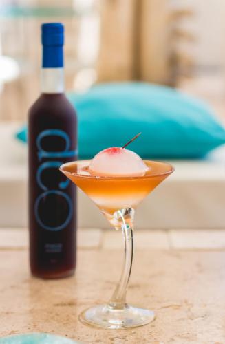 a drink in a martini glass next to a bottle of wine at DCO Suites Lounge & Spa in Máncora