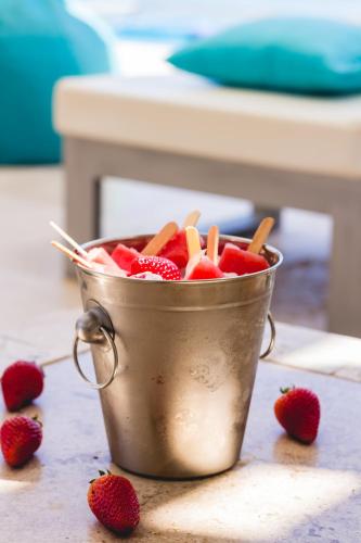 a metal bucket filled with strawberries on a counter at DCO Suites Lounge & Spa in Máncora