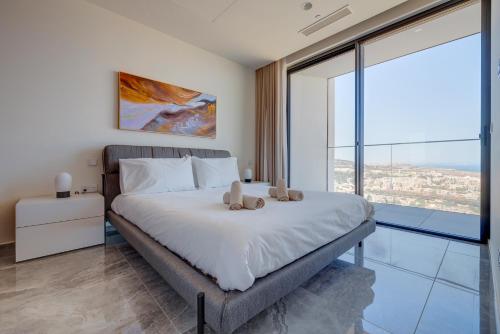 a bedroom with a bed with two teddy bears on it at Mercury Tower Apartments in St Julian's