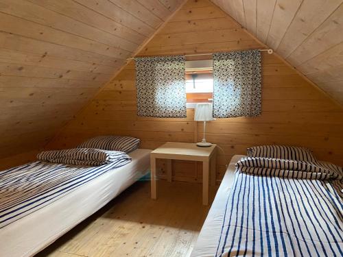 two beds in a room with a attic at Domki Balos in Karwia
