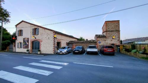 a parking lot with cars parked in front of a building at 16 Bis-Gîte-Hôtel-Appartement in Marssac-sur-Tarn
