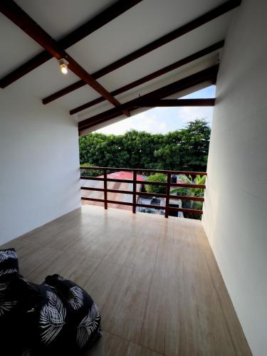 a room with a wooden floor and a balcony at Kalamoana House in Gili Trawangan